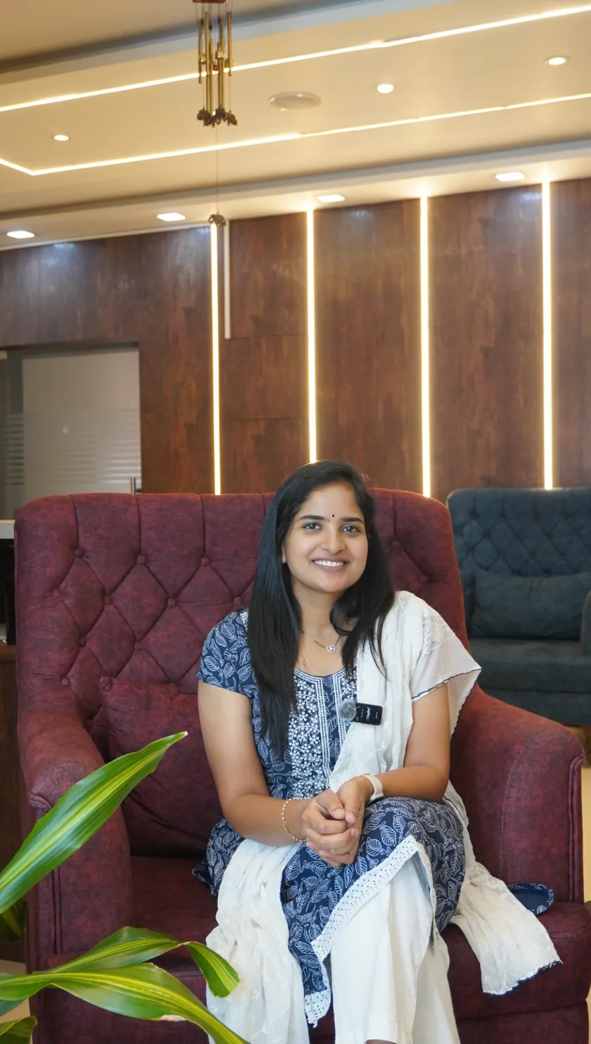 Dr. Srilakshmi V. Champati smiling, seated in a blue and white outfit